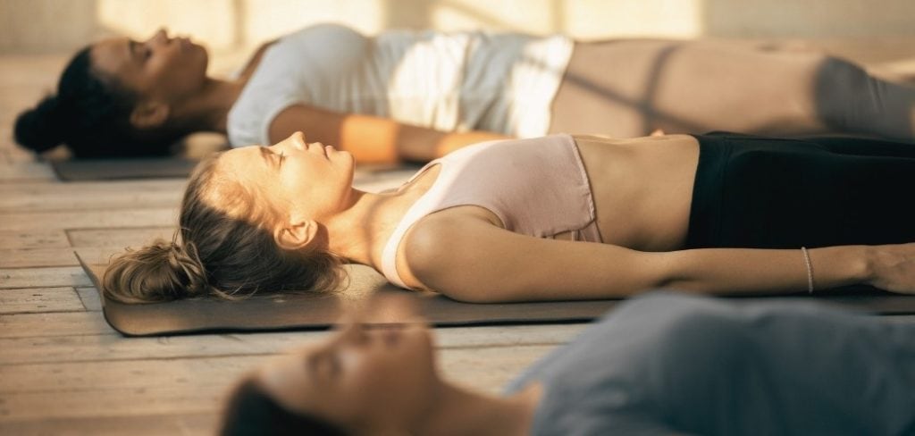 Women laying on the floor doing yoga