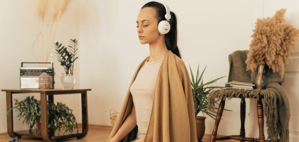Woman meditating with headphones on while listening to music