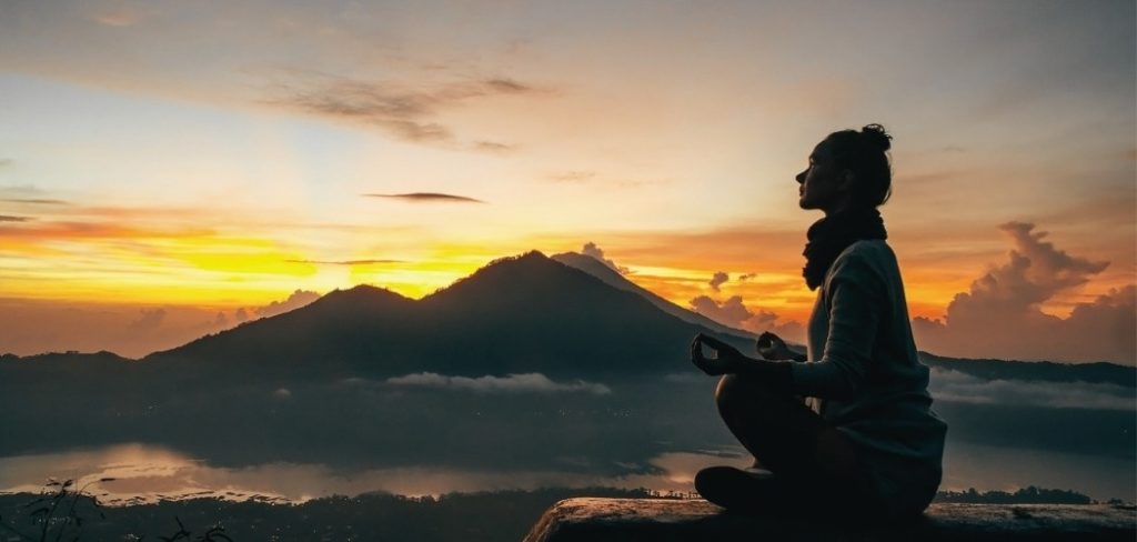 Woman meditating on a mountaintop