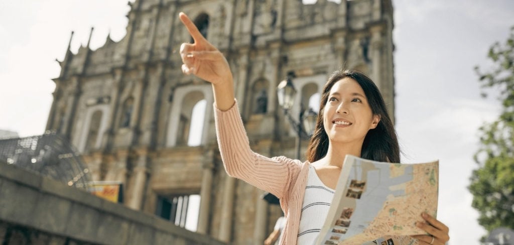 Woman speaking French holding a map and pointing