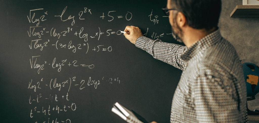 Man doing math problems on a blackboard