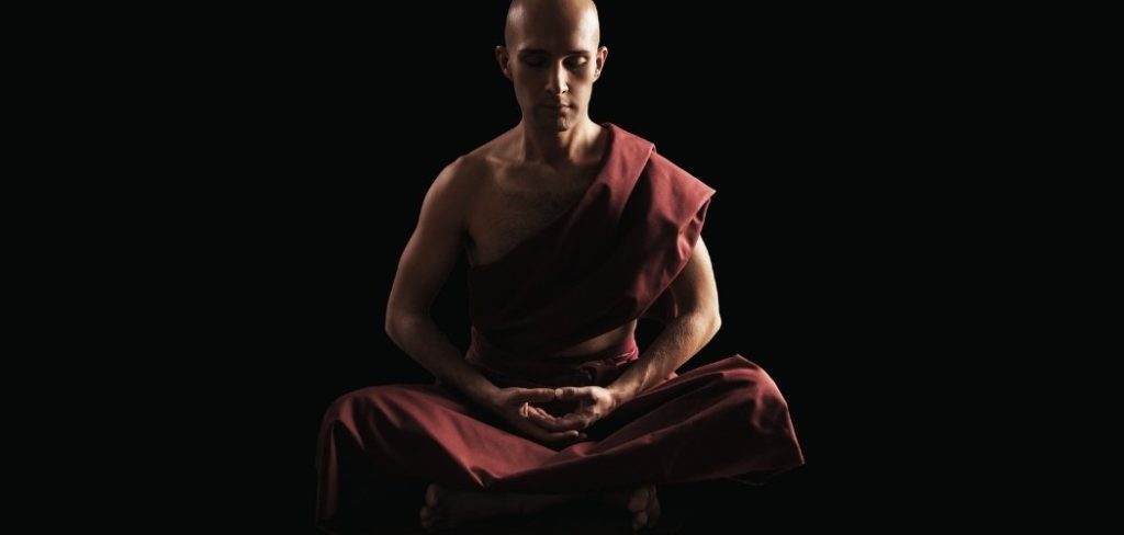 Shaolin monk meditating while crossing hands in the lotus position