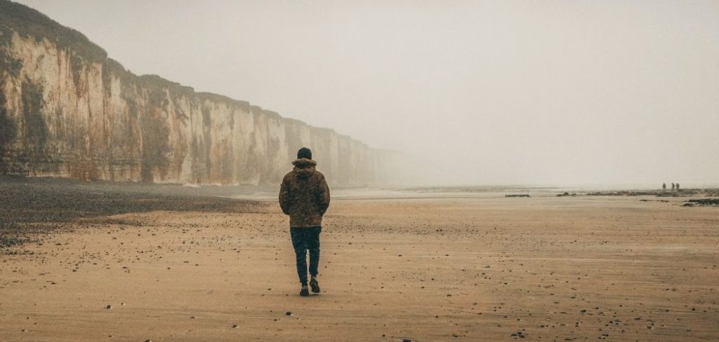 Man walking alone down the beach