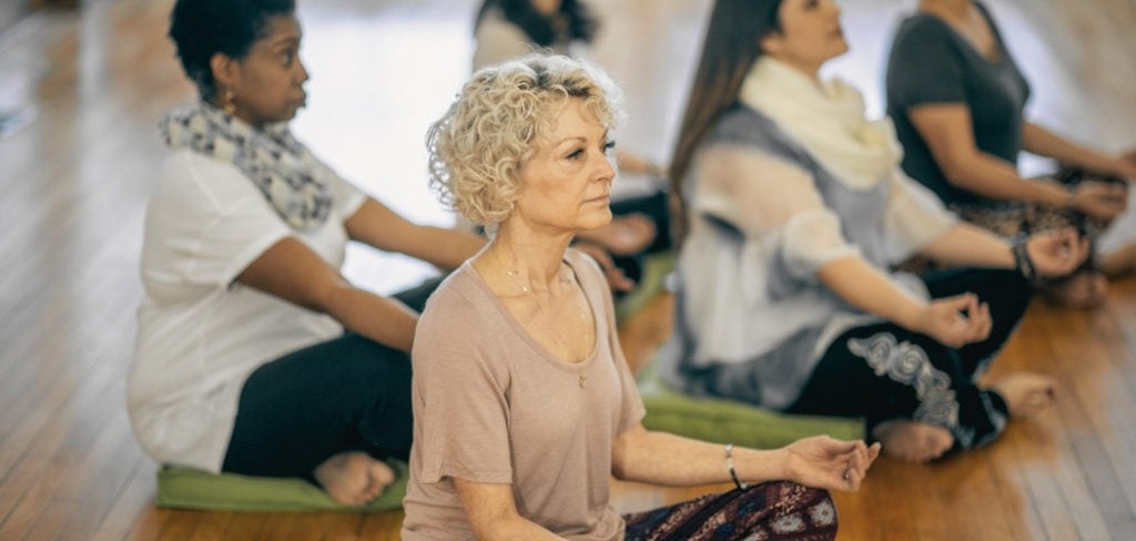 Woman meditating in a group setting