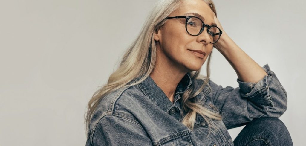 Gray haired woman with glasses looking contemplative