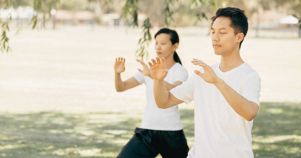 Two people practicing movement meditation in the park