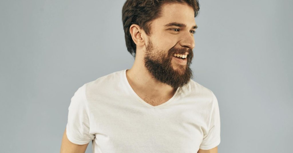 Man with beard smiling and repeating mantras for self love