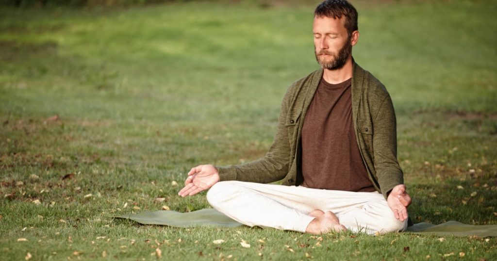 Man sitting in a field meditating