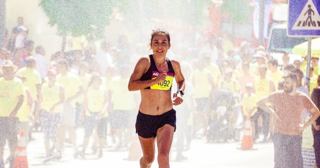 Woman running a marathon with spectators behind her