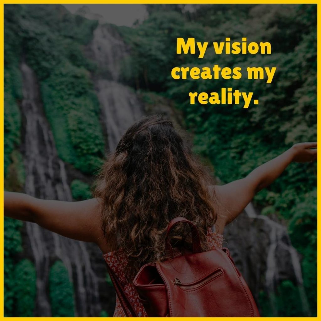 Woman staring at waterfall with the text 'my vision creates my reality'