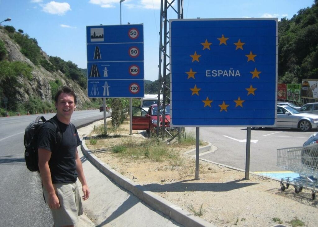 Man standing in front of the border crossing between France and Spain