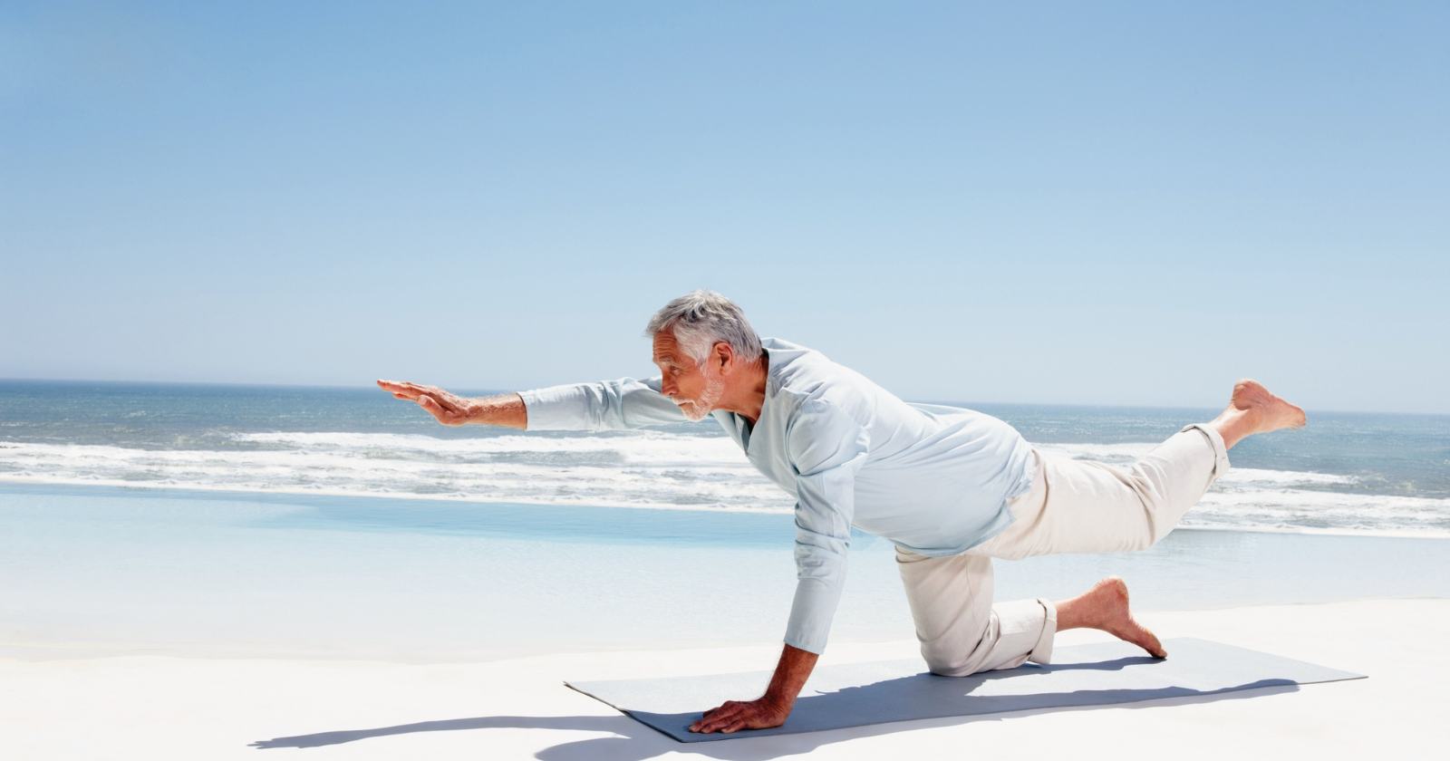 Older adult doing yoga on the beach